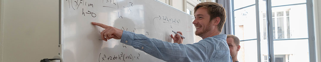 Students writing on a whiteboard
